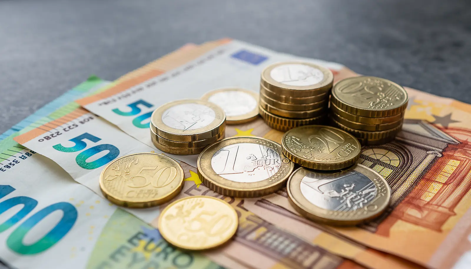 Symbolische Darstellung von Euro-Geldscheinen und Münzen in Gold- und Silberfarben